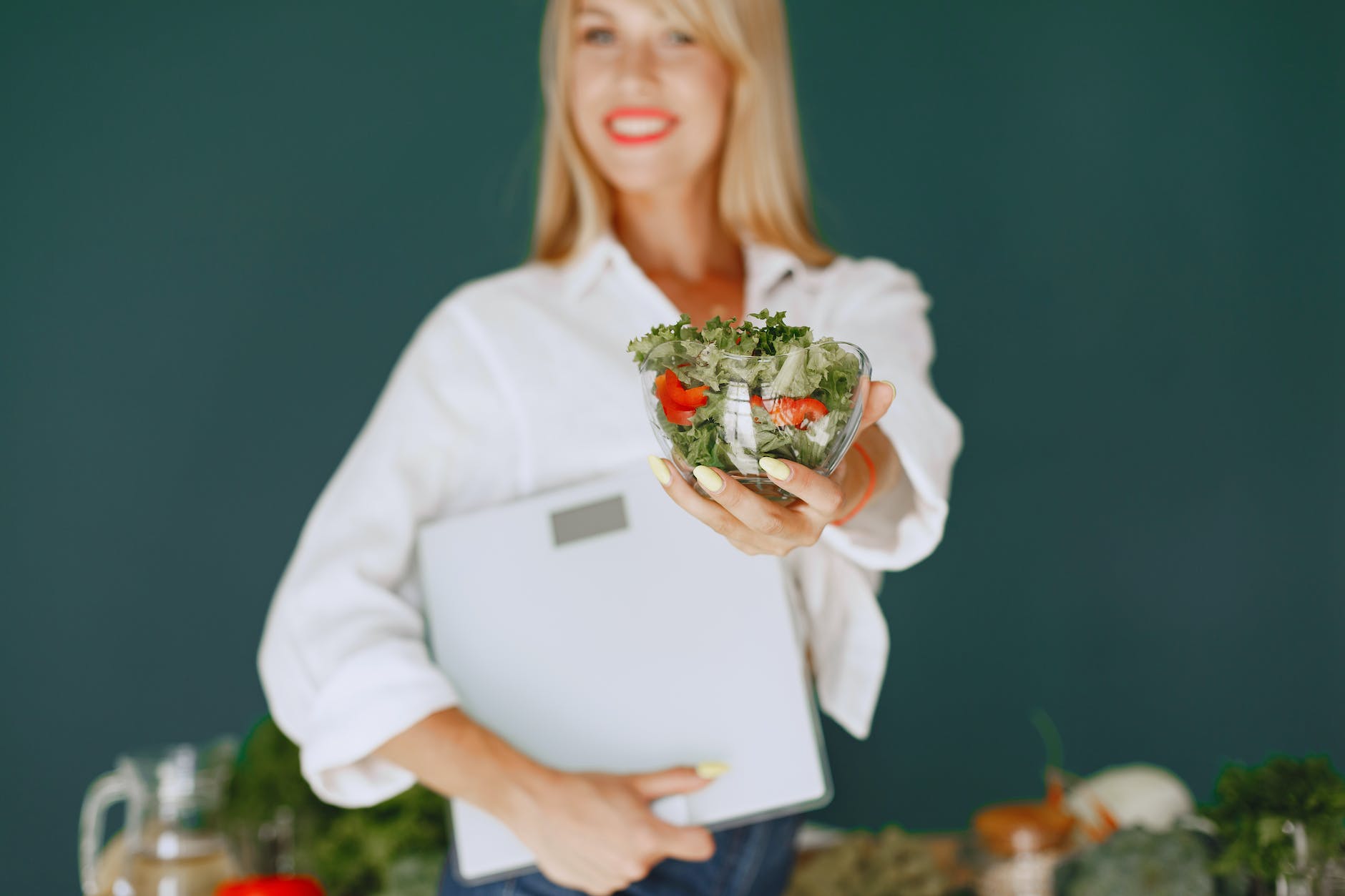 woman holding a bowl with salad and smiling